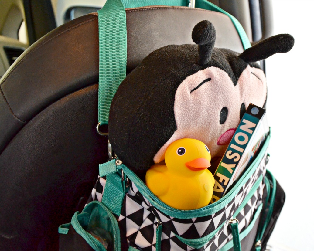 Get road trip ready with car organization tips. Hang a baby bag over the front seat so your child has access to their road trip essentials. 