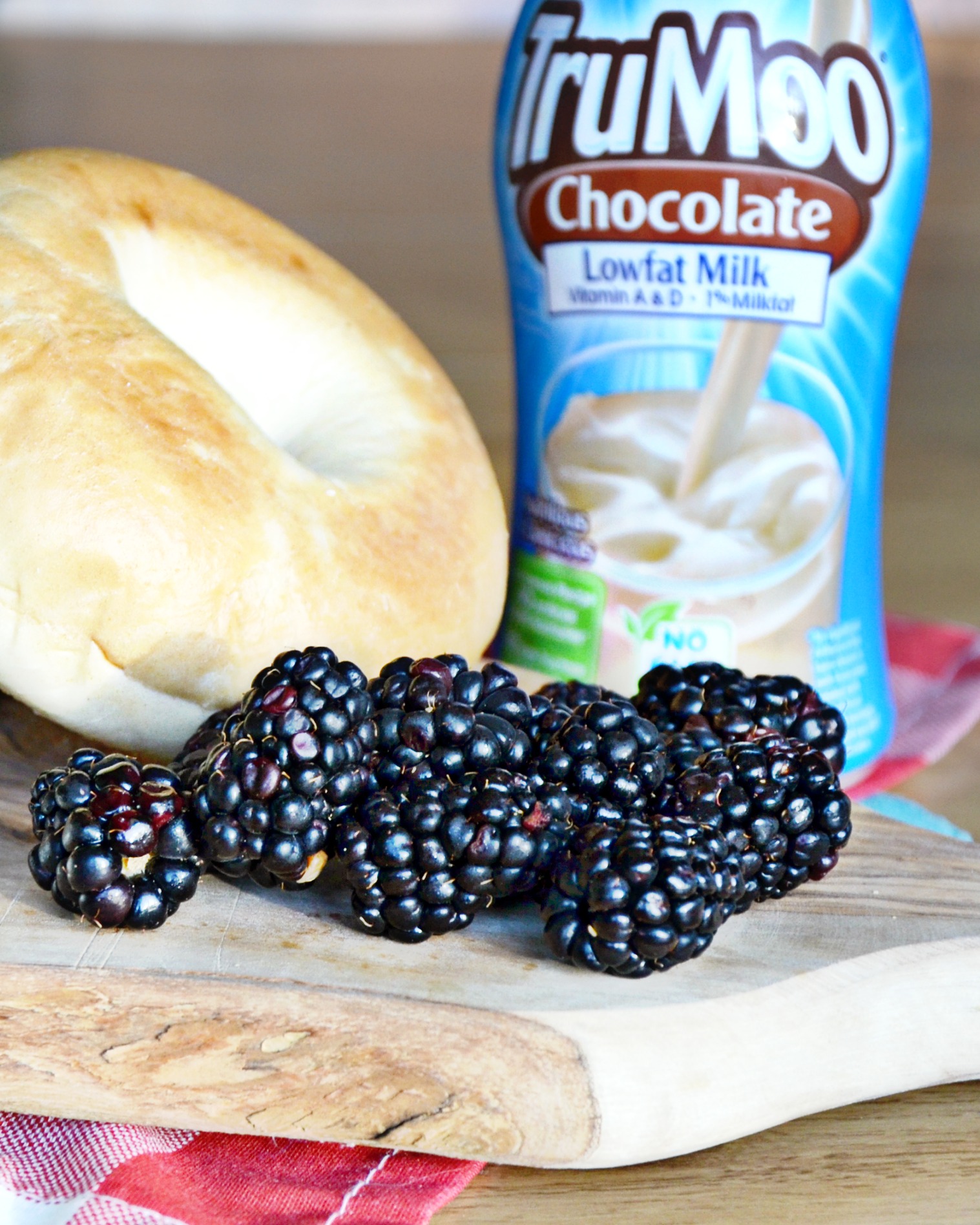 Bagels, cream cheese, blackberries and chocolate milk are a great nutritious snack. 