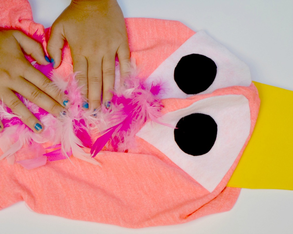 Glue a feather boa to a pink hoodie to make an easy DIY flamingo costume.