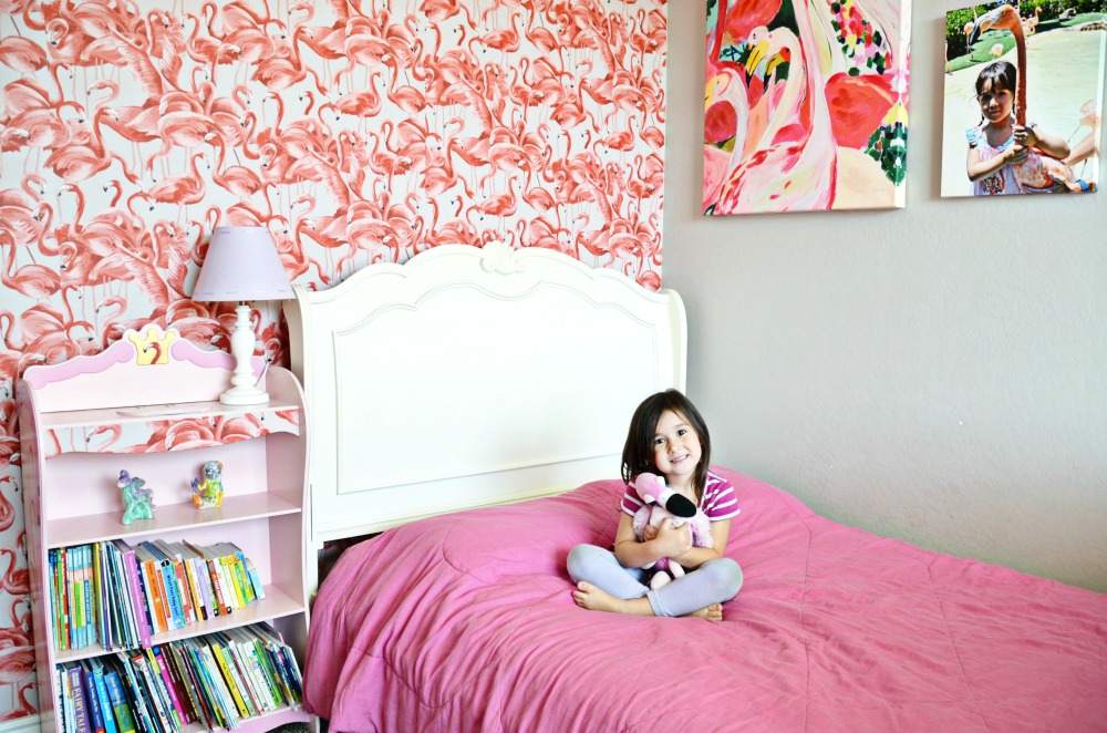 This cute little girl loves her new flamingo bedroom.